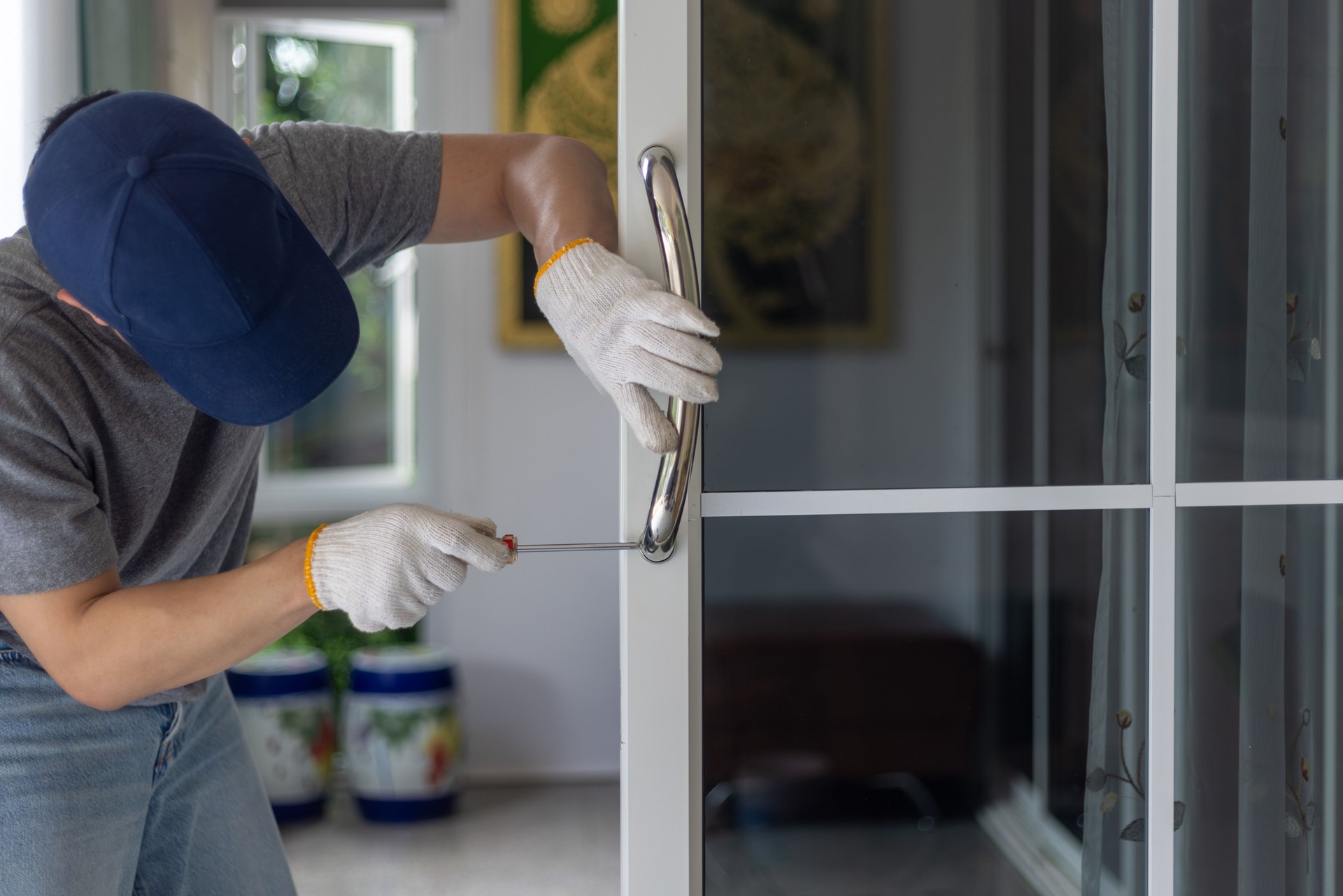 Worker install handle on aluminium swing door.
